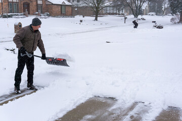 Old midwestern man shoveling snow during snow storm