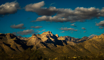 2022-02-23 THE SANTA CATALINA MOUNTAINS WITH A CACTUS FIELD AND DARK CLOUDS IN A BLUE SKY IN TUCSON...