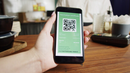 QR code, covid vaccination passport control close-up. Scanning coronavirus electronic medical certificate on smartphone in cafe or restaurant, green zone.