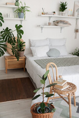 Stylish interior of modern bedroom with houseplants