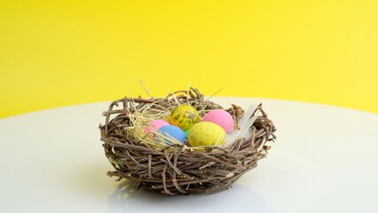 Easter eggs in nest. Holiday celebration concept. Minimal holiday season concept, yellow background, copy space