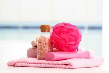 Clean towel, cosmetic products and bath sponge on table