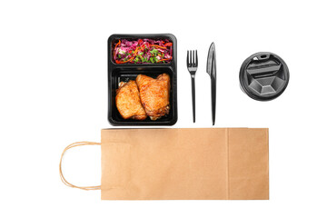 Lunch box with food, cutlery, cup and paper bag on white background