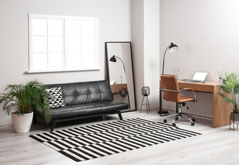 Trendy interior of living room with sofa, workplace and carpet