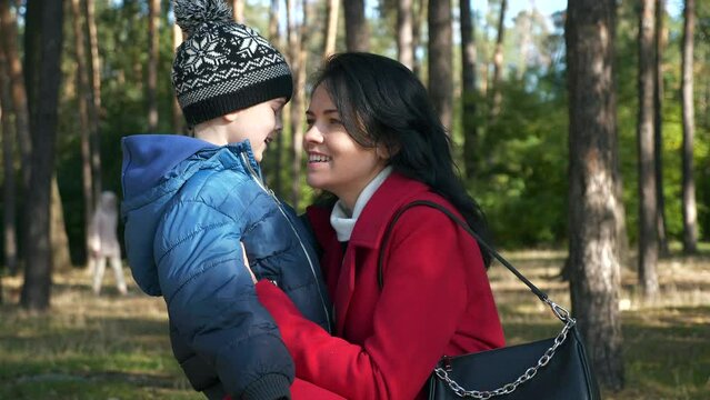 Young Loving Mother Hugs Son Talking to Child. Woman Rest With Kid Boy in Park. Sunny Day. 2x Slow motion 60fps 4K
