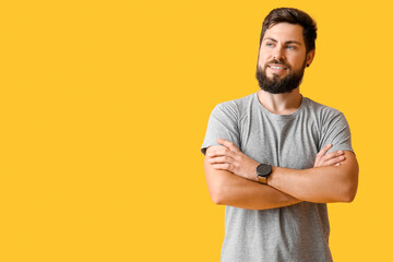 Handsome man in grey t-shirt on yellow background