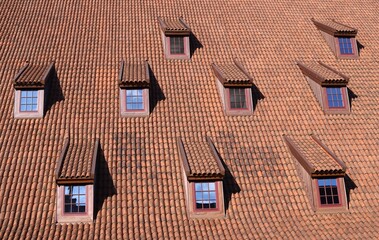 Wielki dach z czerwonych dachówek z lukarnami - obrazy, fototapety, plakaty