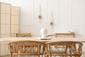 Tray with vase on wooden table in light dining room