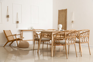 Fototapeta na wymiar Wooden table with wicker chairs in interior of light dining room