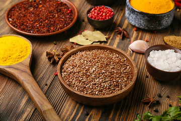 Bowl of flax seeds on wooden background, closeup