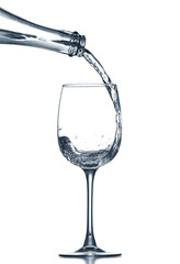 Pouring of clear water in glass isolated on white