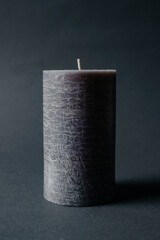 grey textured candle on black background. High quality photo