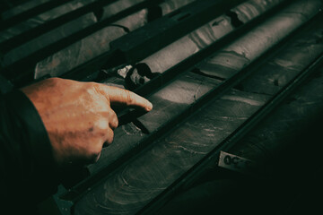 Geological gold core samples with team of mining workers measuring drilled rock top view. Selective...