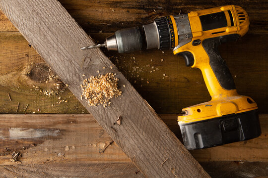 Drill sitting on top of wood planks