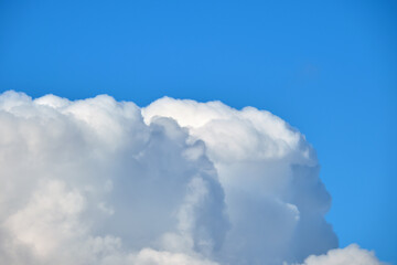 Bright landscape of white puffy cumulus clouds on blue clear sky