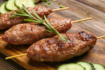 Board of skewers with tasty lula kebab on wooden background, closeup