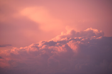 Colorful evening landscape with soft pastel coloured clouds on watercolor tinted sunset sky. Abstract nature background