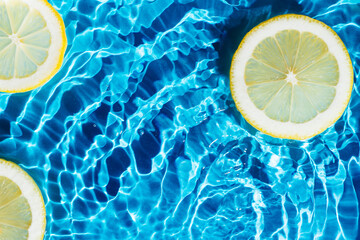 Transparent fresh exhilarant wave water with flecks background, lemon citrus slices. Healthy eating beach. Flat lay