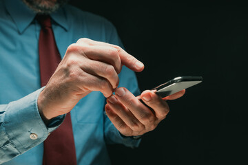 Businessman using mobile smart phone, close up of hand and device