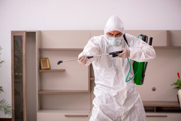 Fototapeta premium Young male contractor doing pest control at home