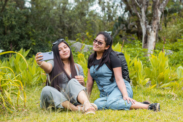 Naklejka na ściany i meble Grupo de dos amigas haciendo un selfie en un parque durante un día de verano. Amistad y vacaciones.viaje,naturaleza