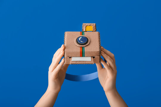 Female Hands With Cardboard Photo Camera On Color Background