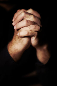 Praying hard for redemption. Hands clasped in prayer.