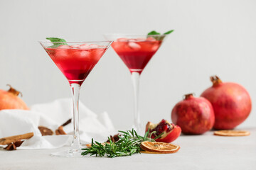 Glasses of tasty pomegranate cocktail on white background