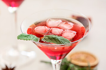 Glass of tasty pomegranate cocktail on white background, closeup