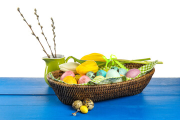 Painted Easter eggs, flowers and pussy willow on table against white background