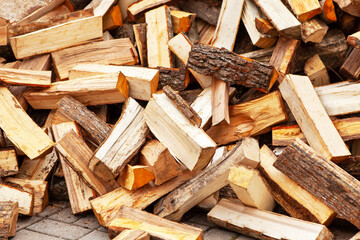 Stock of firewood for heating the house. The trees were cut down and split into firewood to be used as heating fuel in fireplaces and stoves, firewood background.
