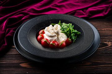 Salad with traditional italian burrata cheese with arugula and tomatoes