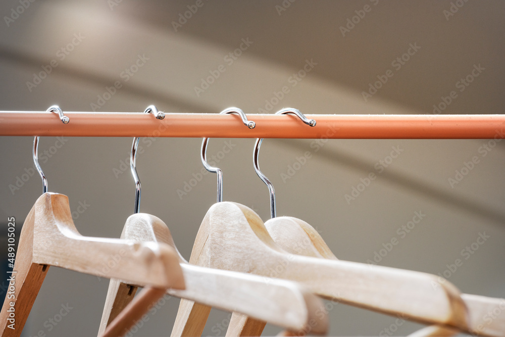 Wall mural Wooden hangers hung on a light brown or tile bar