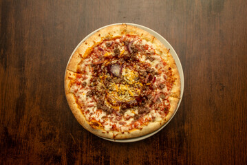 Small slice pizza with ground beef, lots of mozzarella cheese, bacon bits, cheddar cheese and barbecue sauce