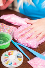 Young kids playing with colorful slime kit with glitter, toys, texture craft balls, and sparkles