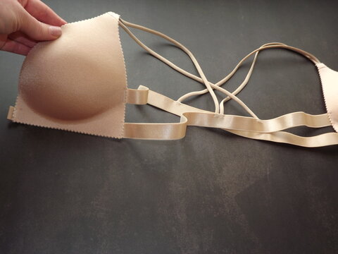 a woman's hand holds a beige bra. High quality photo