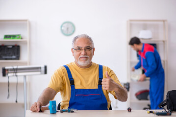 Obraz premium Two male repairmen working at workshop