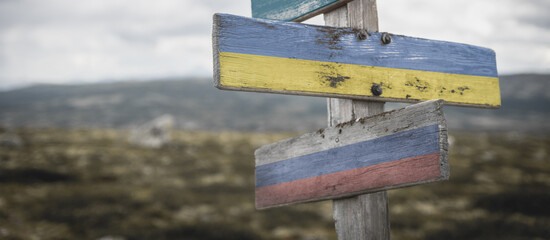 nato, ukraine and russia flag on signpost outdoors in nature.