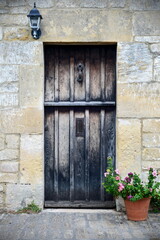 Old wooden front door of a house with flowers