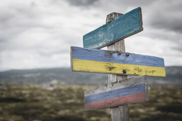 nato, ukraine and russia flag on signpost outdoors in nature.