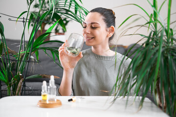 Woman drinking glass with Chlorophyll water, antioxidant beverage. Healthy lifestyle 