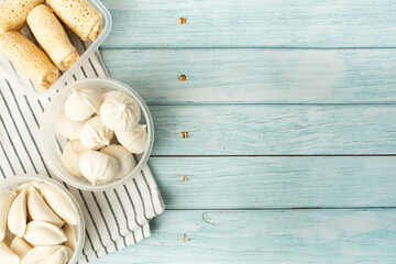 semi-finished products on a blue table, dumplings, khinkali, pancakes in containers