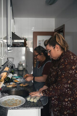 senior mother teaching her daughter how to cook