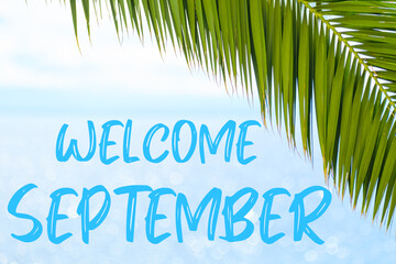 Welcome September text on the background with palm leaf and blue sea. Template of a greeting card, postcard or advertisement of a tour agency. 