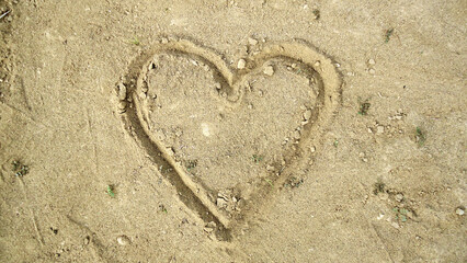 Fototapeta na wymiar Heart Drawn on the Sand and Mud Ground - Heart Drawn on sand surface