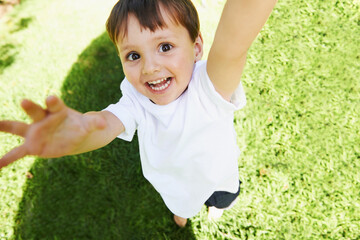 Yay Its time to play. High angle view of a little boy reaching up into the air.