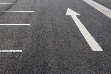 white direction arrow on road in car park