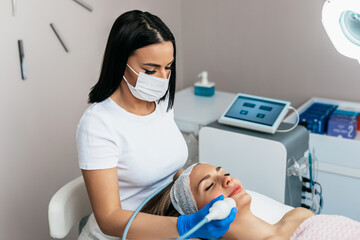 A middle-aged woman enjoys a skin rejuvenation treatment at a beauty salon.