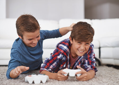 You Always Beat Me. Shot Of Two Young Boys Teasing Each Other While Playing Video Games.