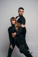 Gymnastic support. Woman and man in black suits, acrobatic exercise